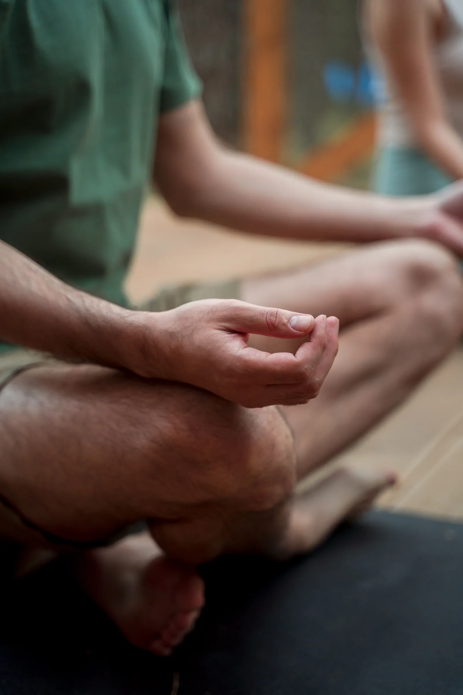 Person sitting cross-legged in meditation with hands resting in a mudra