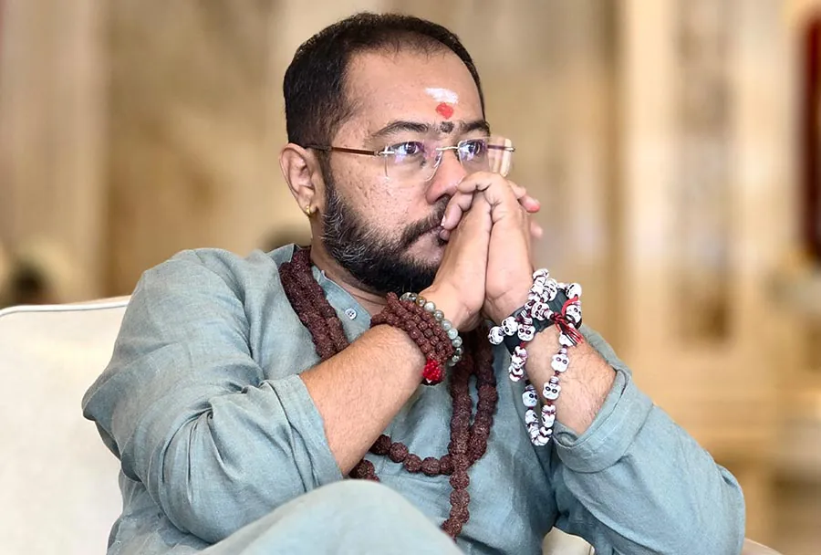 Swami Bhadraanand, founder of Bhagavad Karma, with hands folded in prayer
