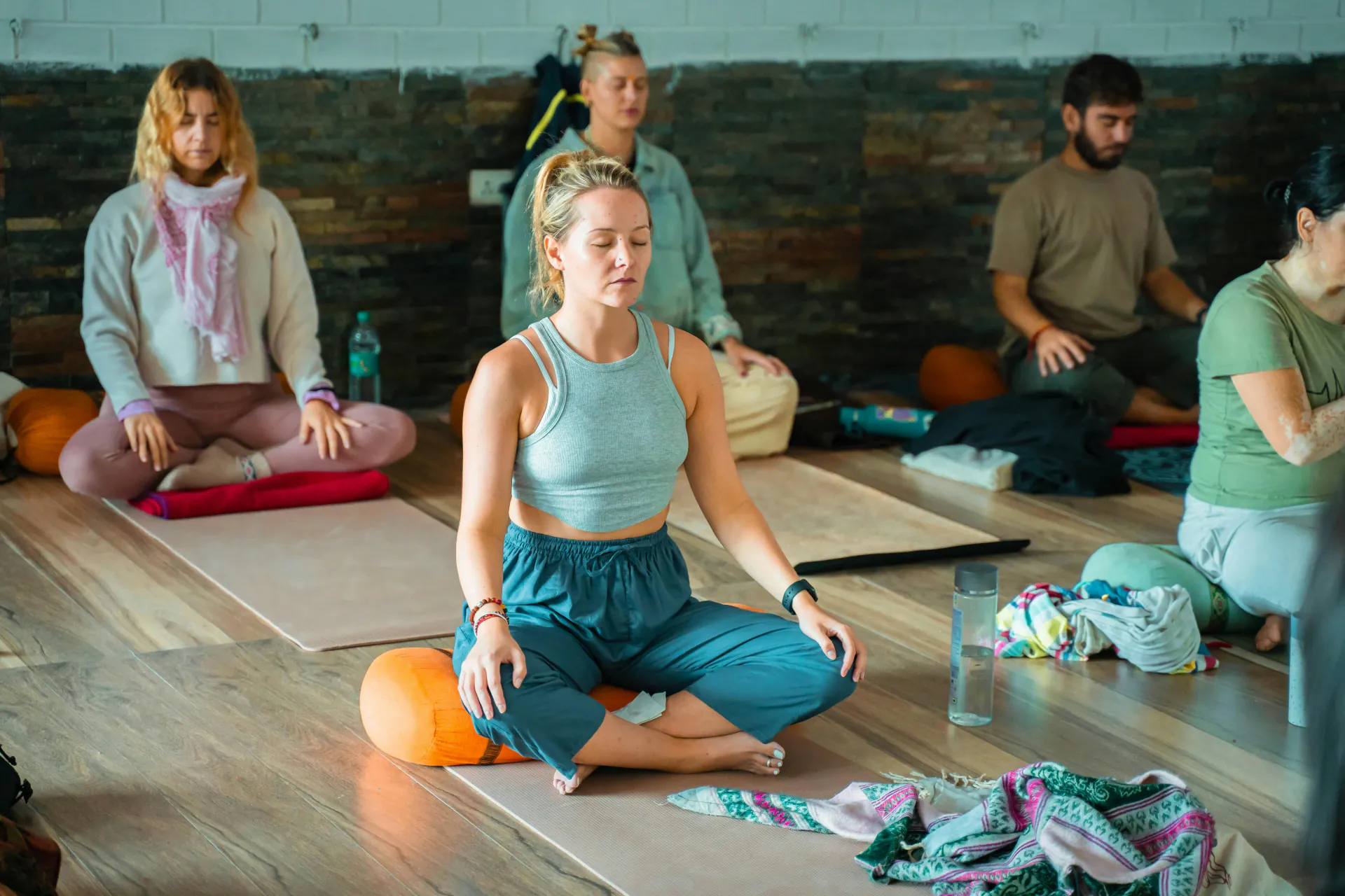 Yoga class practising seated breathing in an ashram studio