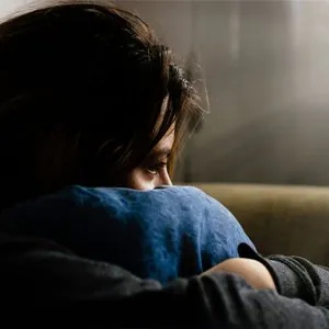 Woman sitting alone looking sad — support for depression