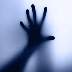 Hand pressed against frosted glass symbolising fear