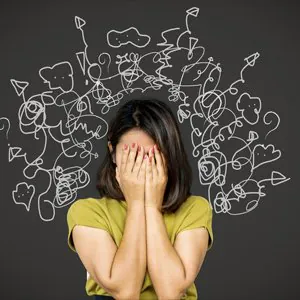 Woman covering her face surrounded by tangled doodles — stress relief