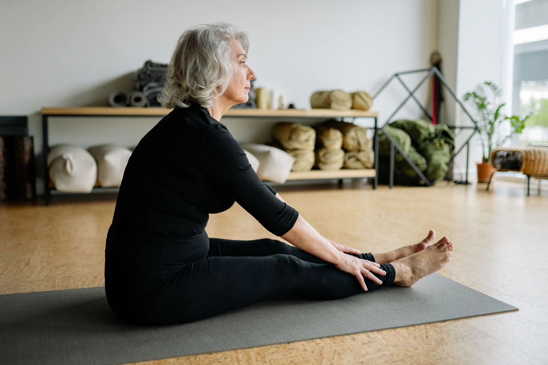 Senior woman stretching on a yoga mat for healthy, active ageing