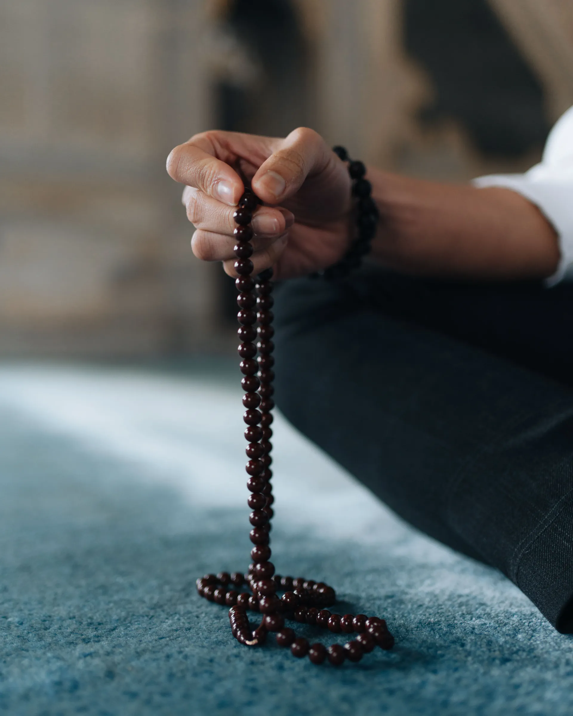 Hand holding prayer beads during quiet contemplation