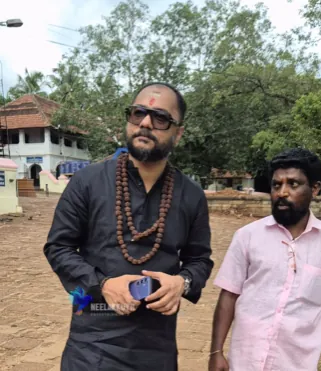 Swami Bhadraanand outdoors with a companion — Neelakkuyil Entertainments reel